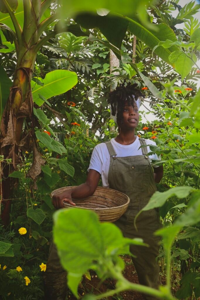 Black Woman Farmer Collecting Vegetables And Flowers